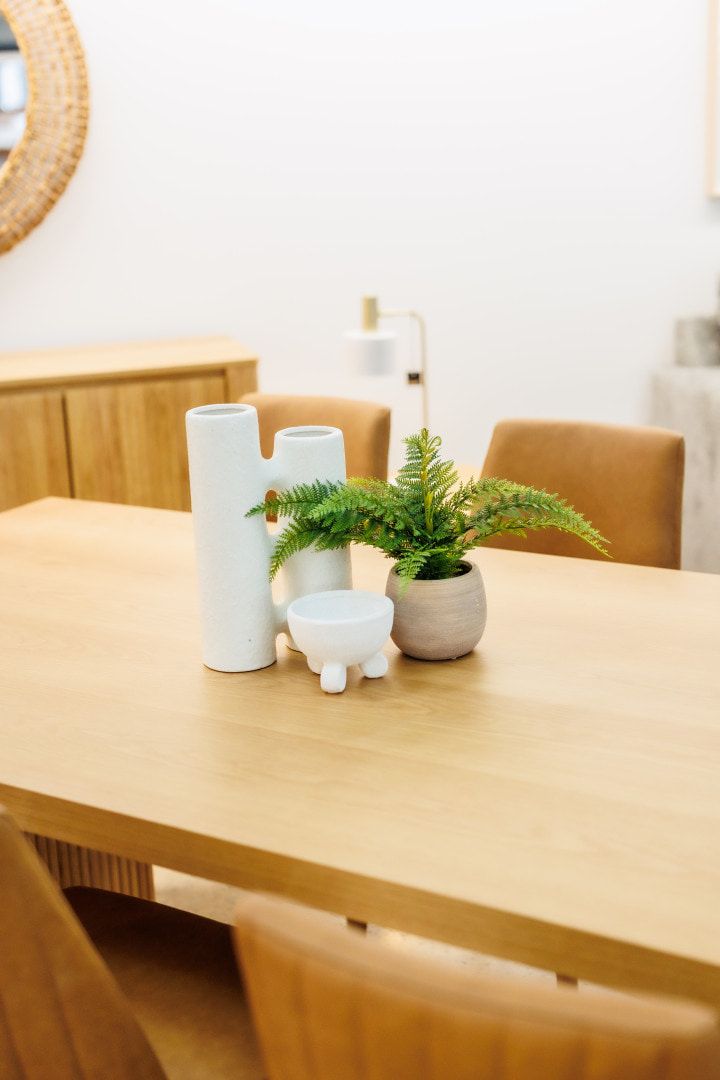 A wooden dining table with a plant and pots arranged on top — The Comfort Zone Darwin In Darwin, NT