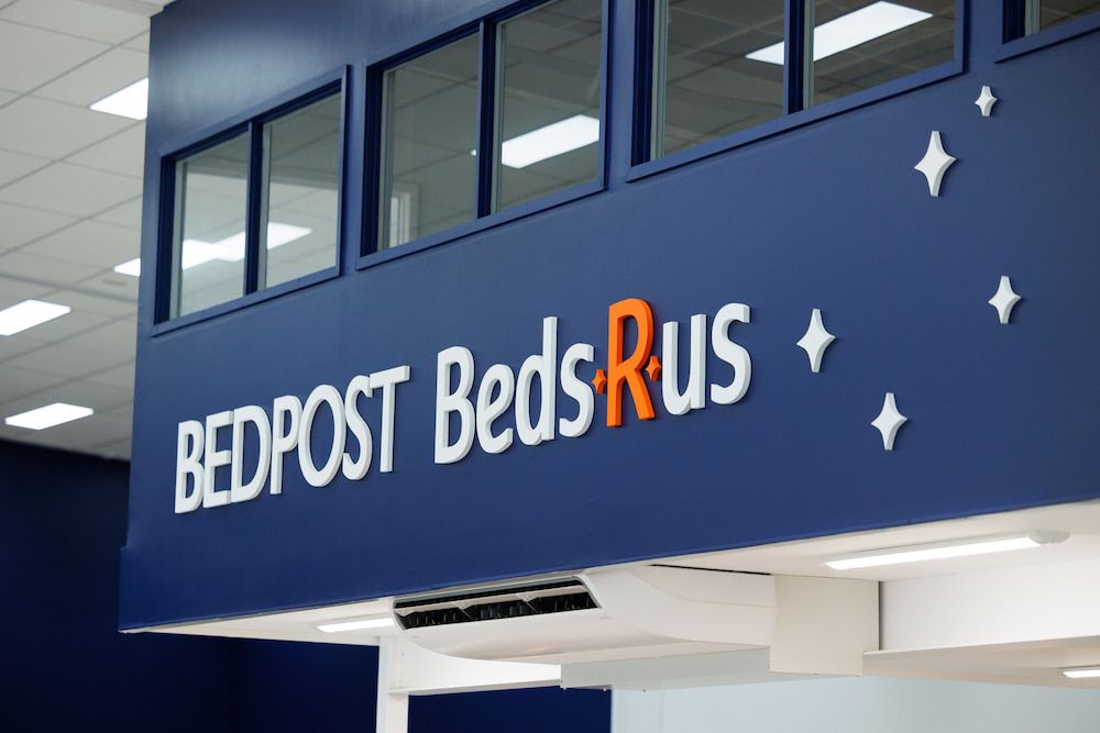 A Blue Sign That Says Bedpost Beds Rus on It — The Comfort Zone Darwin In Winnellie, NT