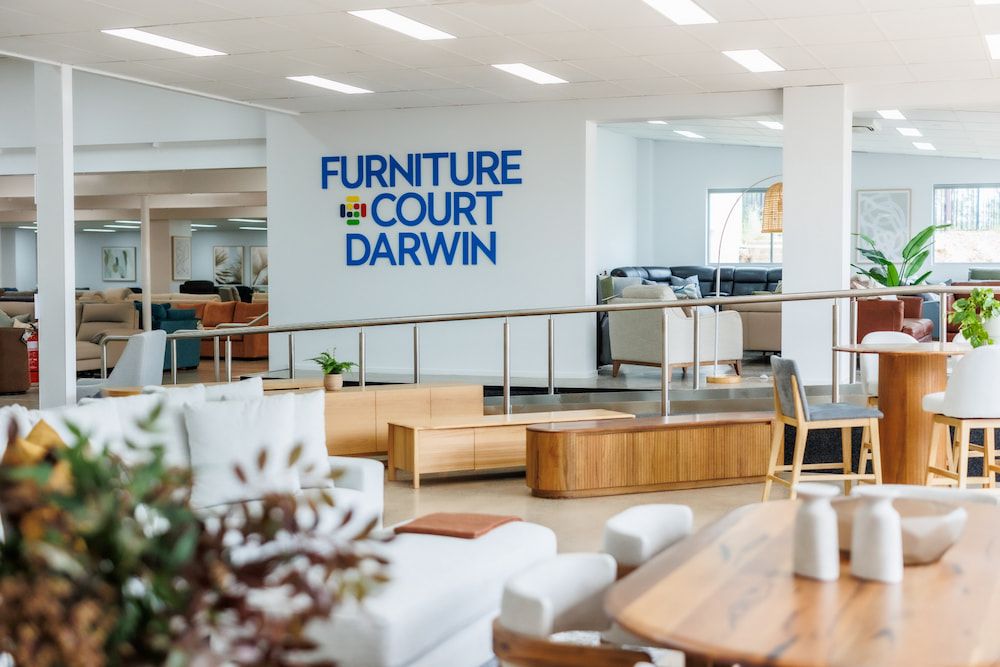 A Large Room Filled With Furniture and a Sign That Says Furniture Court Darwin — The Comfort Zone Darwin In Winnellie, NT