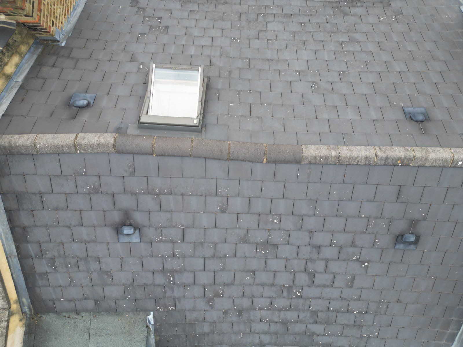 Drone survey of a slate roof showing ridge tiles, vents and rooflight