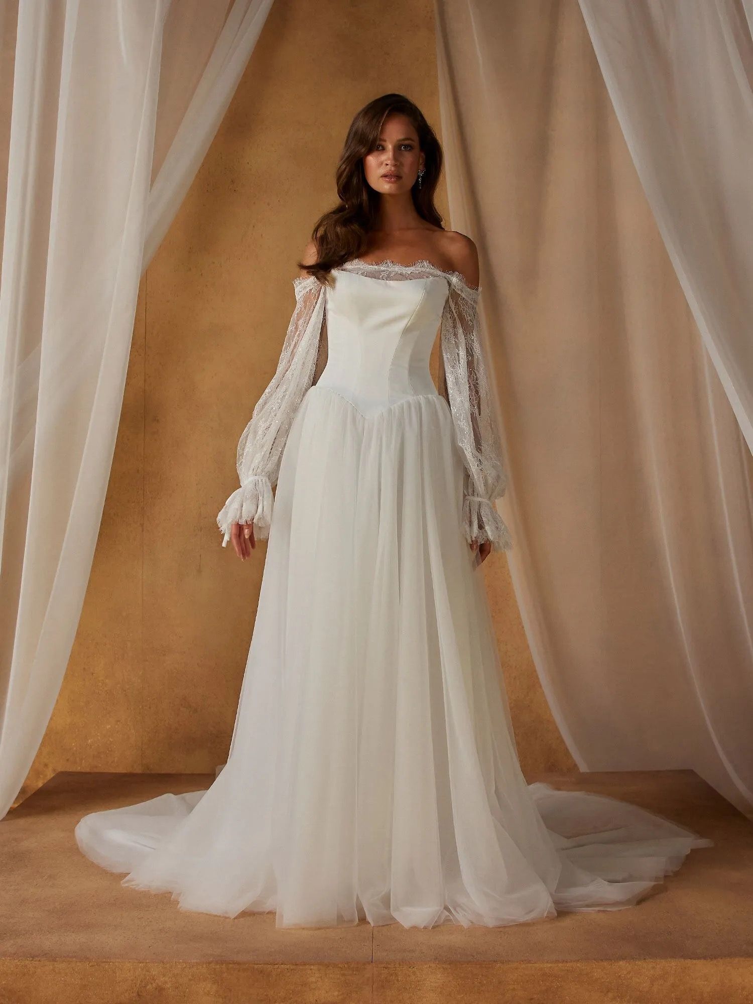 Our Nordic wedding dress exists in the space between modern and whimsical. Blending the two styles seamlessly for a look that feels both romantic and fashionable in the most effortless way.
The clean, velvet satin bodice begins at a contemporary scoop neckline. With the option to be worn strapless or with spaghetti straps for added support. Curved seamlines create shape throughout the bodice, ending at the sharp Basque waist that cinches the figure.