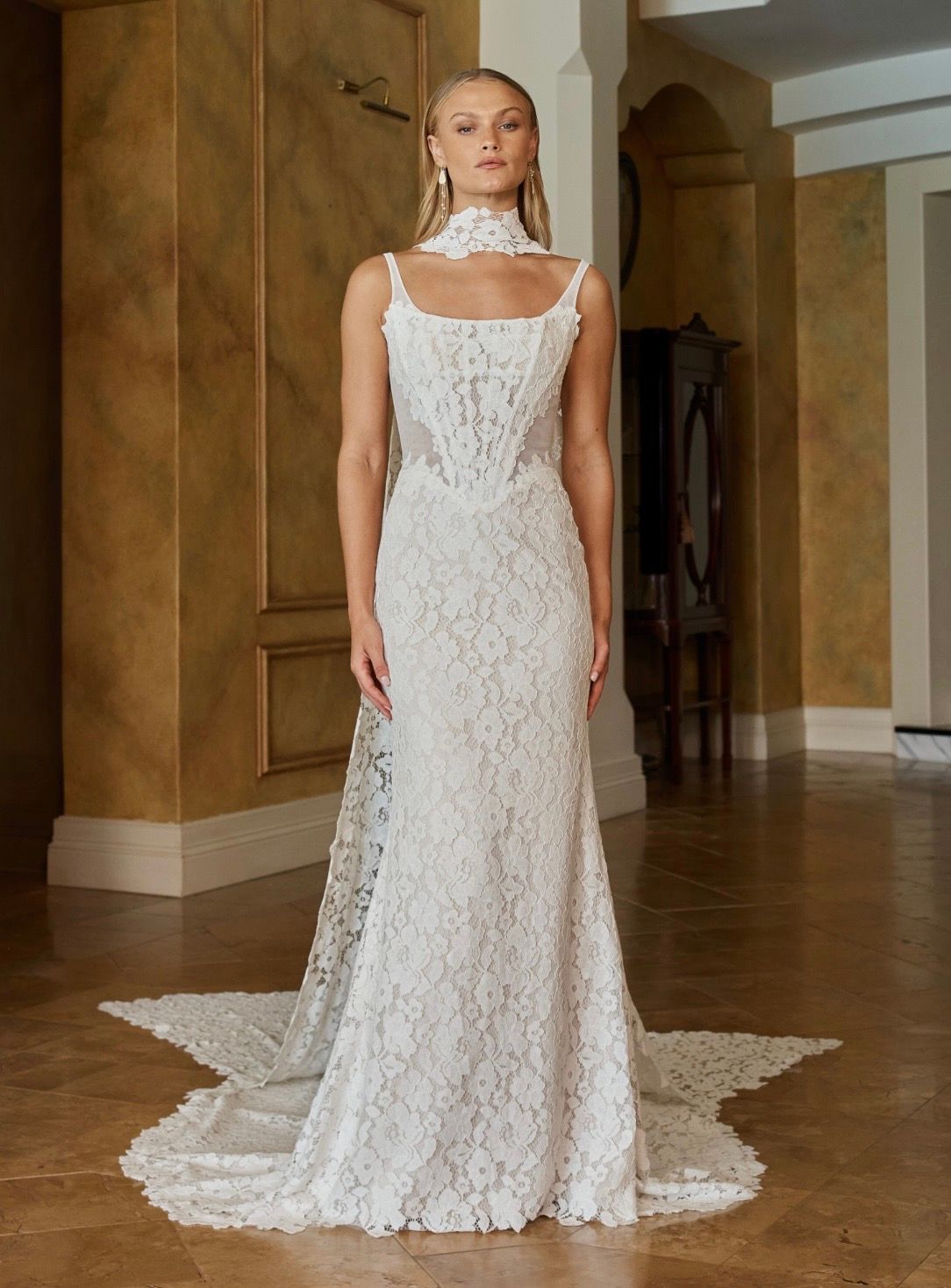 Sexy and feminine is our Ora wedding dress with striking vintage-inspired lace and a unique modern elevated design. For our modern Madi brides who want a statement style that feels and looks chic and youthful. Made even more dramatic with a long length matching full lace scarf.
Hitting all the fashion trends, her modern square neckline with tapered illusion shoulder straps frames the illusion tulle bodice. Layered with corded floral lace across the bust and down the centre-front. Using negative space to create sexy curved illusion side corset panels that snatch the figure for the ultimate feminine waistline.