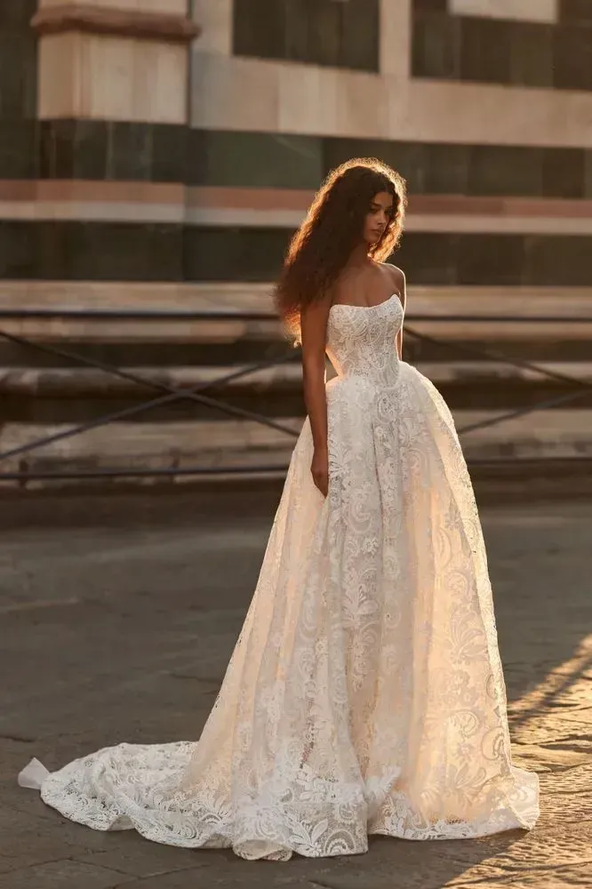 Romantic princess lace gown with a sleeveless corset bodice and a full princess skirt. Comes with a high-neck long-sleeved lace bolero that allows you to switch between two different looks on your big day.
For a completely dreamy ensemble, finish off with a lace-adorned Almarose tulle veil.