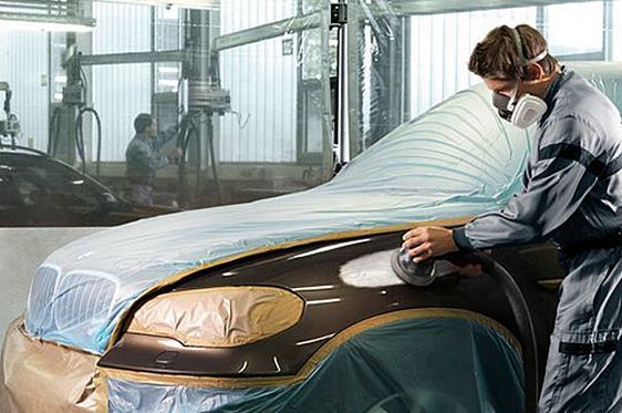 Auto Body Worker Sanding a Car Hood in a Workshop — Supalook Smash Repairs In Port Macquarie, NSW