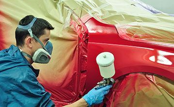 Person in a Respirator Spraying Red Paint on a Car — Supalook Smash Repairs In Port Macquarie, NSW