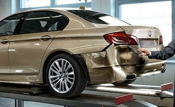 Gold BMW Sedan With Rear-end Damage, on a Lift — Supalook Smash Repairs In Port Macquarie, NSW