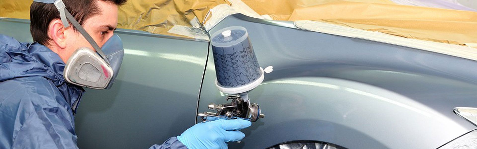 Person in Protective Gear Sprays Paint on a Car — Supalook Smash Repairs In Port Macquarie, NSW