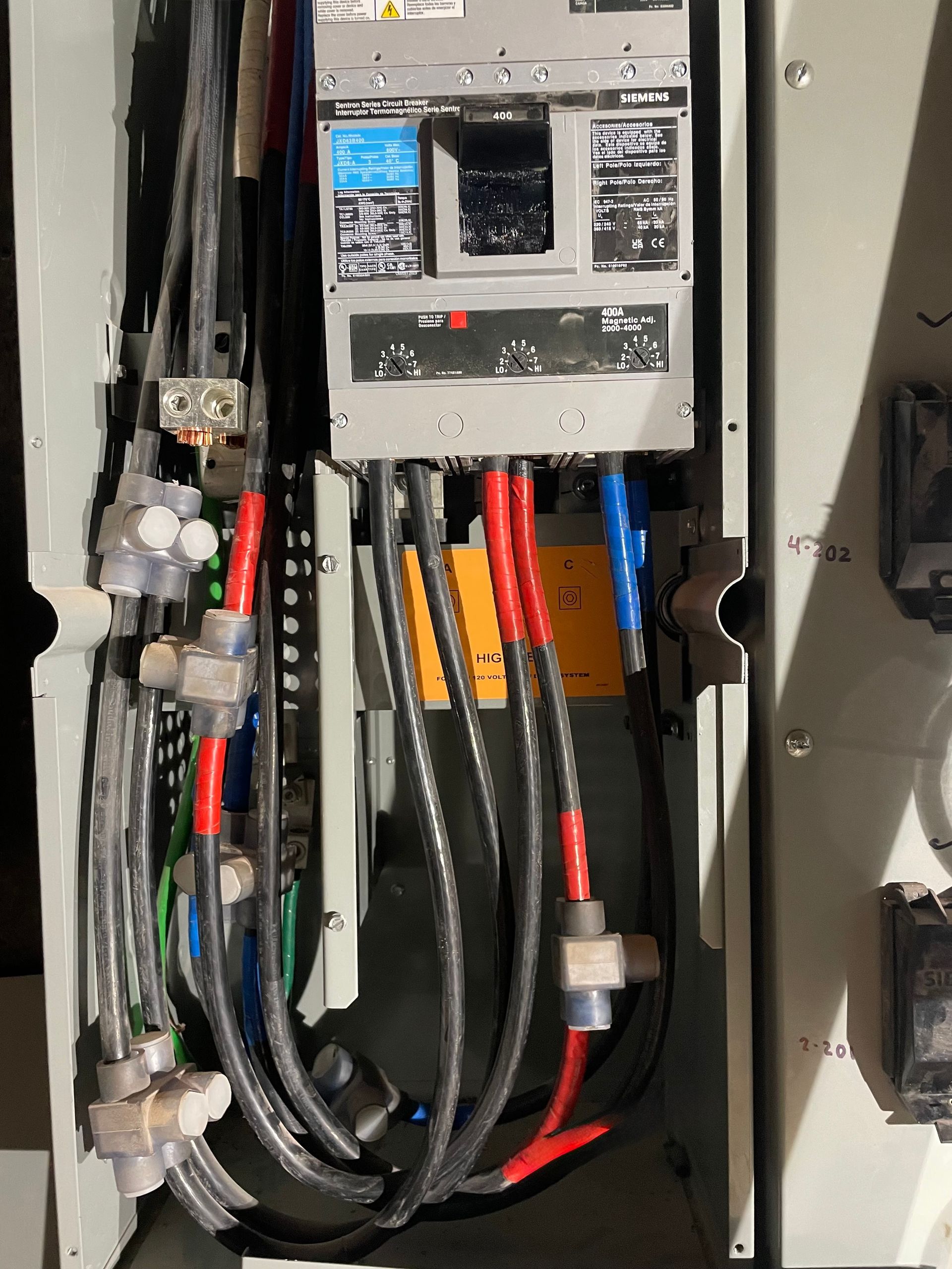Person using a multimeter to test electrical wiring in a panel.