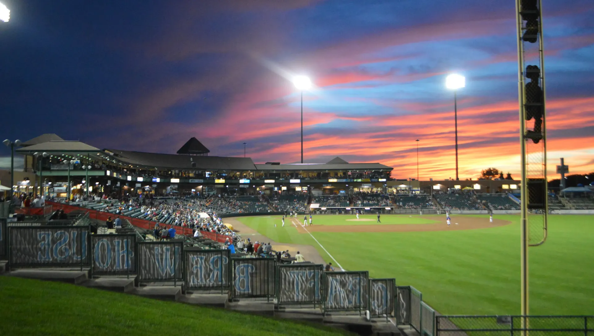 A baseball field with a sunset in the background