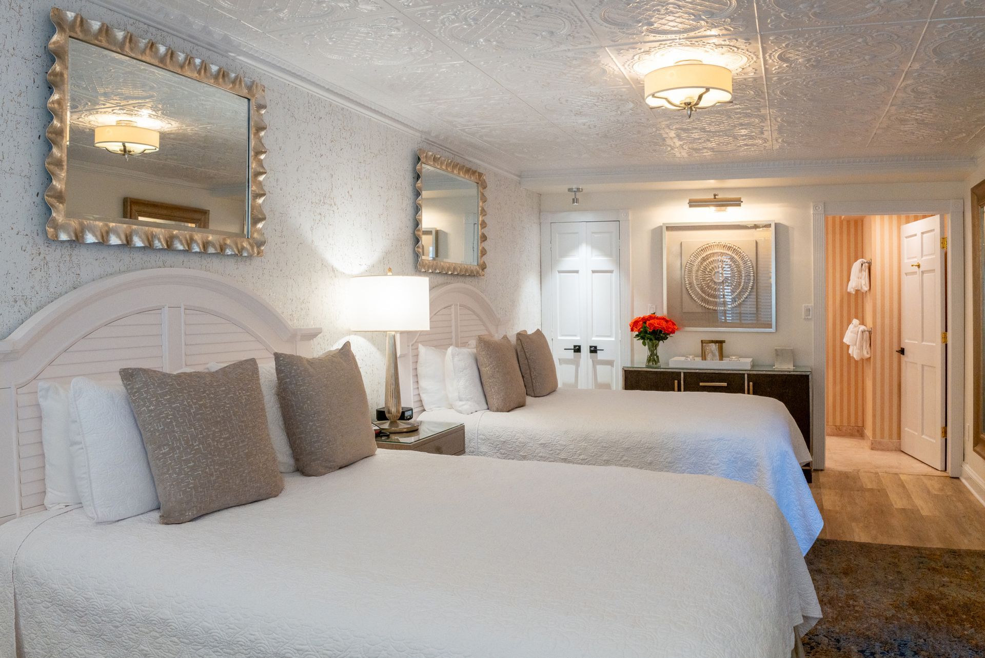 A hotel room with two beds and a mirror on the wall