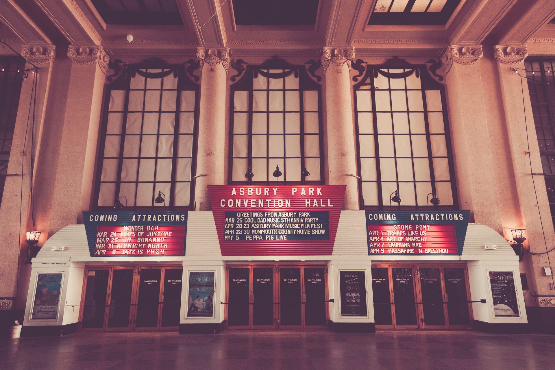 A large building with a red sign that says august four convention hall