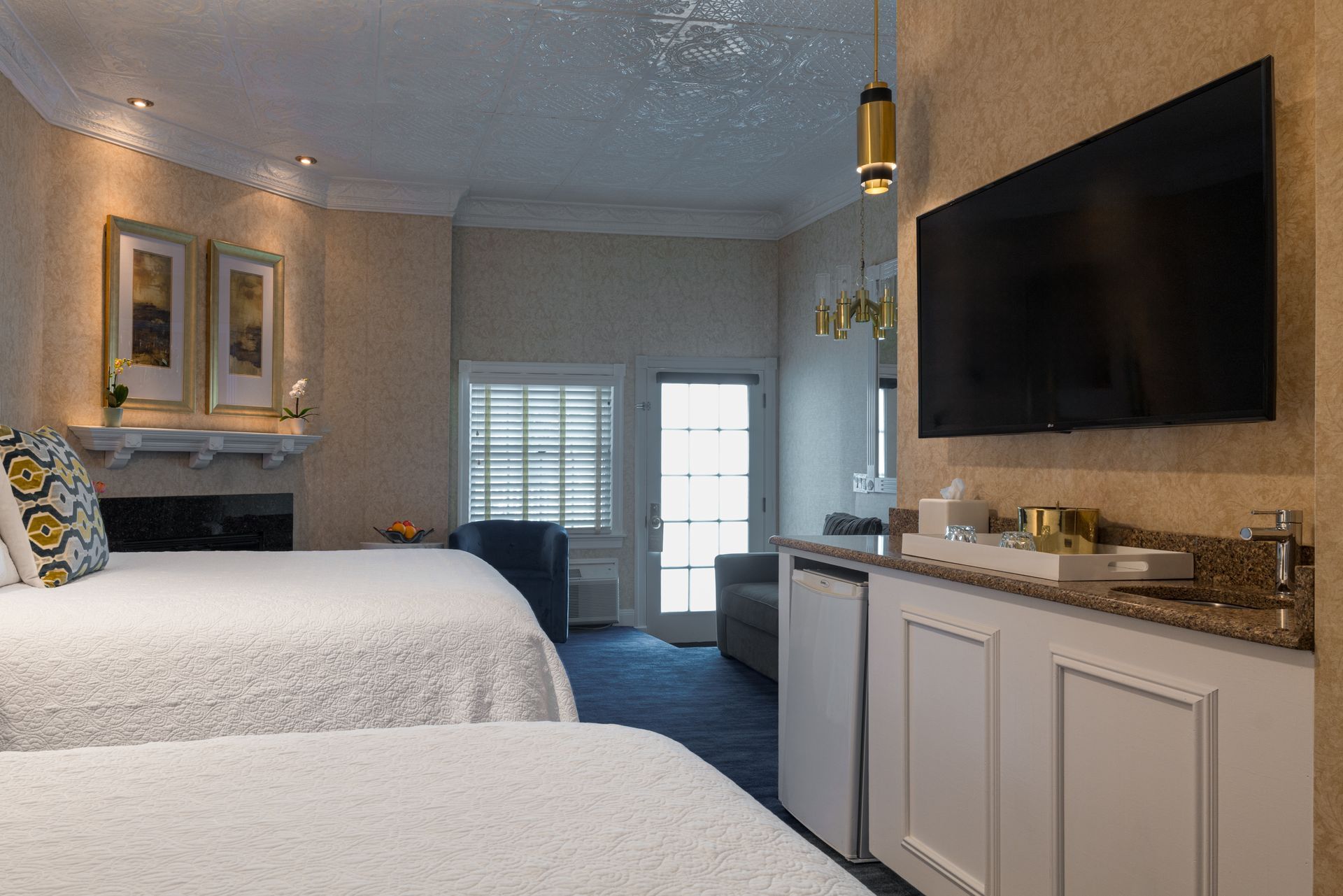 A hotel room with two beds and a flat screen tv.