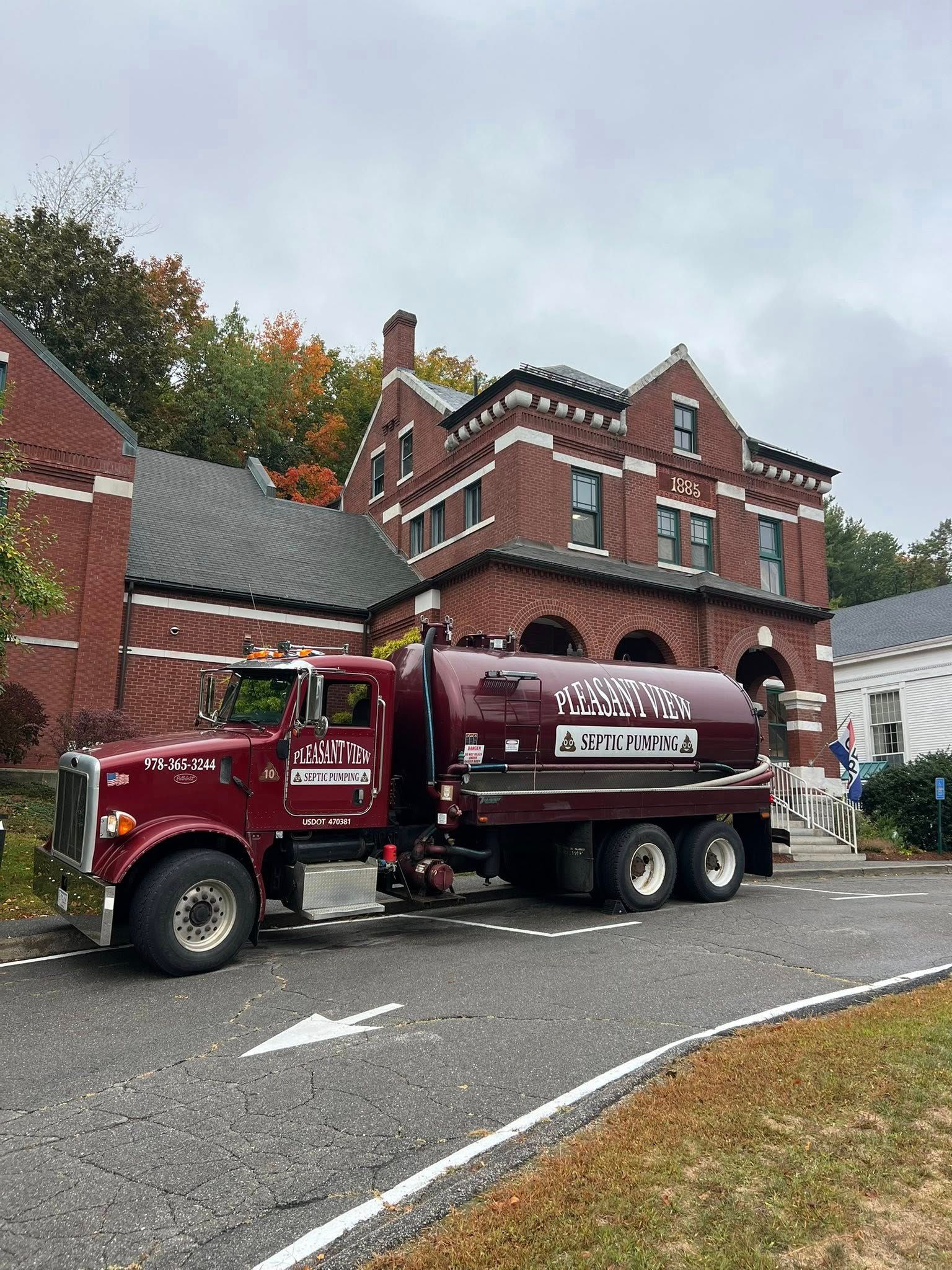 A red sewage tank trunk, pumping out sewage from a septic tank in a residential setting.
