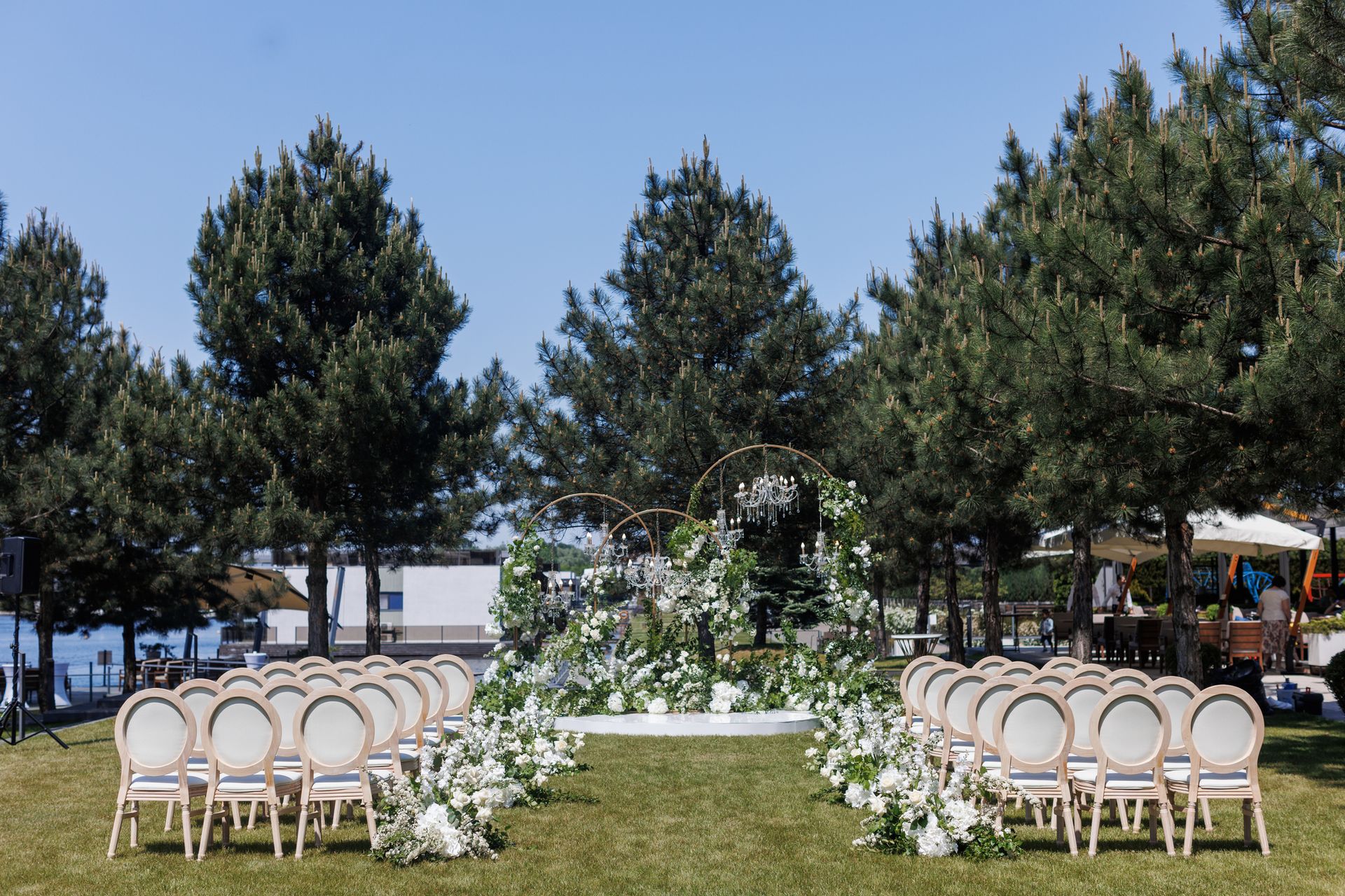 A wedding ceremony is taking place in the middle of a field surrounded by trees.