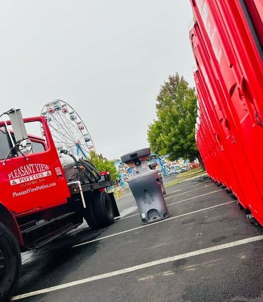 A red tow truck is parked next to a ferris wheel