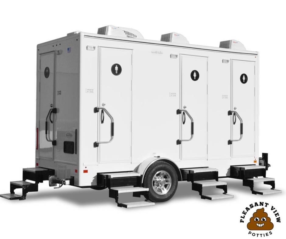A white trailer with three toilets on it is sitting on a white surface.