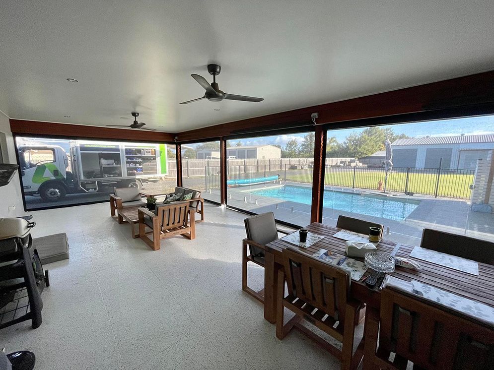 A Living Room With A Table And Chairs — Affordable Screens & Blinds in Thabeban, QLD