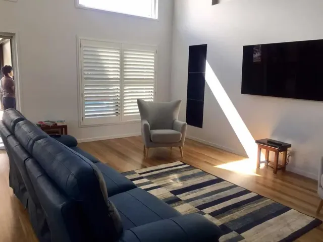 A Living Room With A Couch, Chair, Rug And Television — Affordable Screens & Blinds in Thabeban, QLD
