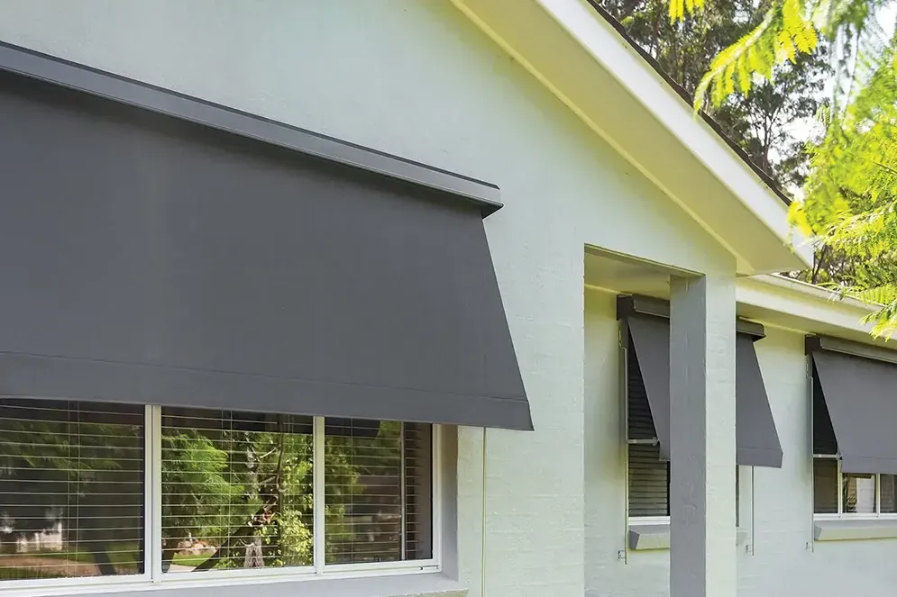 A White House With Black Awnings On The Windows — Affordable Screens & Blinds in Thabeban, QLD
