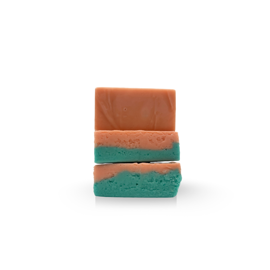 Three stacked pieces of colorful fudge: brown on top, teal in the middle, and brown/teal on the bottom.