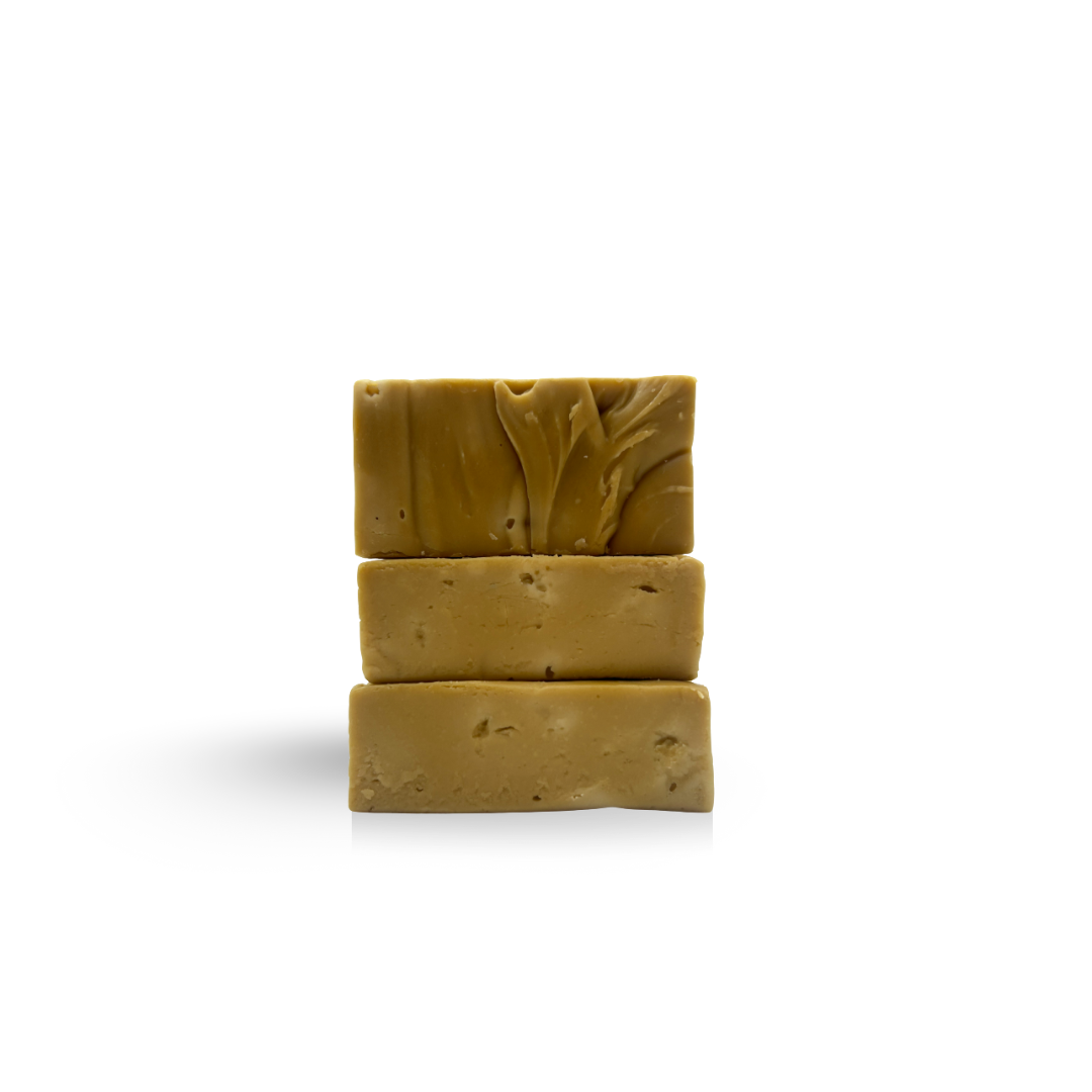Three stacked rectangular pieces of golden-brown fudge on a white background.