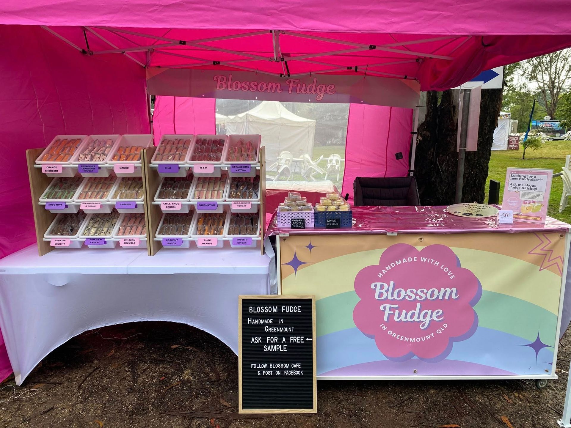 Pink Blossom Fudge stand at an outdoor event, displaying fudge and signage.