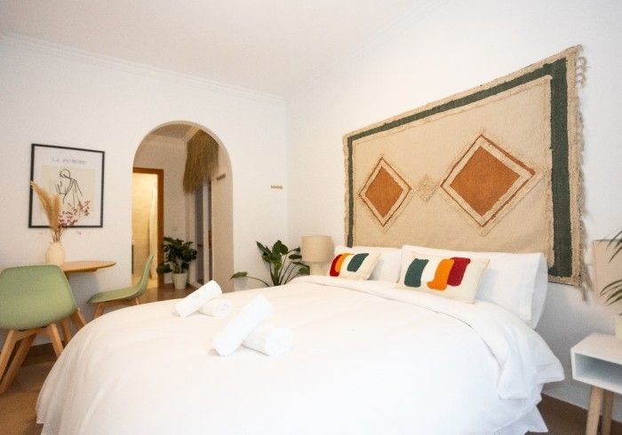 Un dormitorio con una cama y una alfombra en la pared.