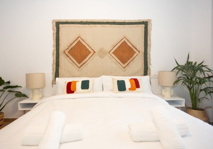 Un dormitorio con una cama y una alfombra en la pared.