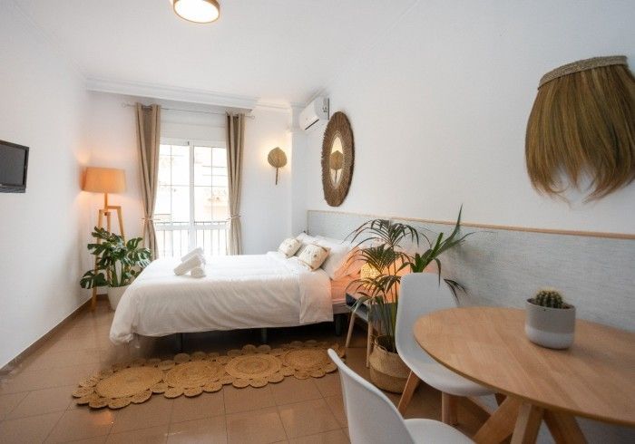Un dormitorio con una cama grande, una mesa y sillas.