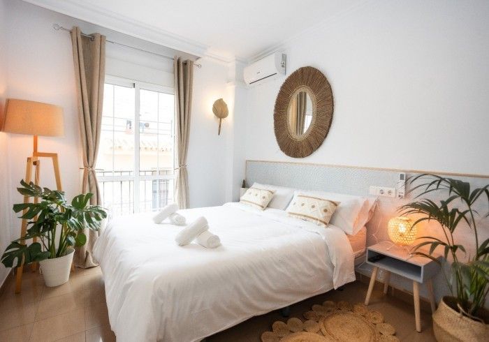 Un dormitorio con una cama grande y un espejo en la pared.