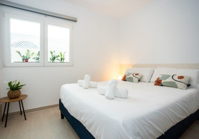 Un dormitorio con una cama king size y dos ventanas.