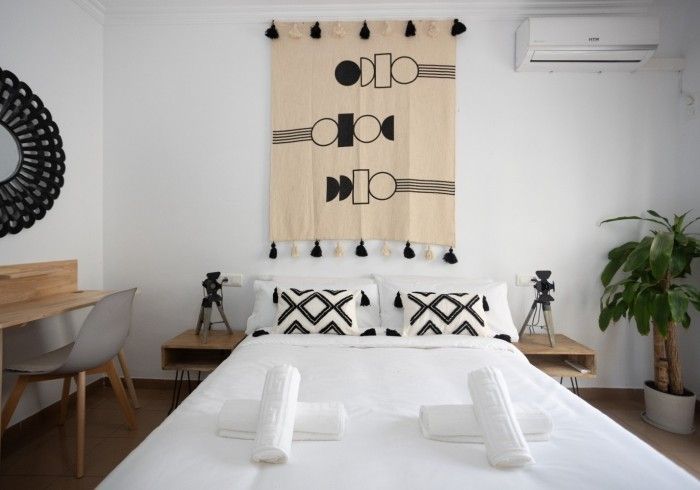 Un dormitorio con una cama y un tapiz en la pared.