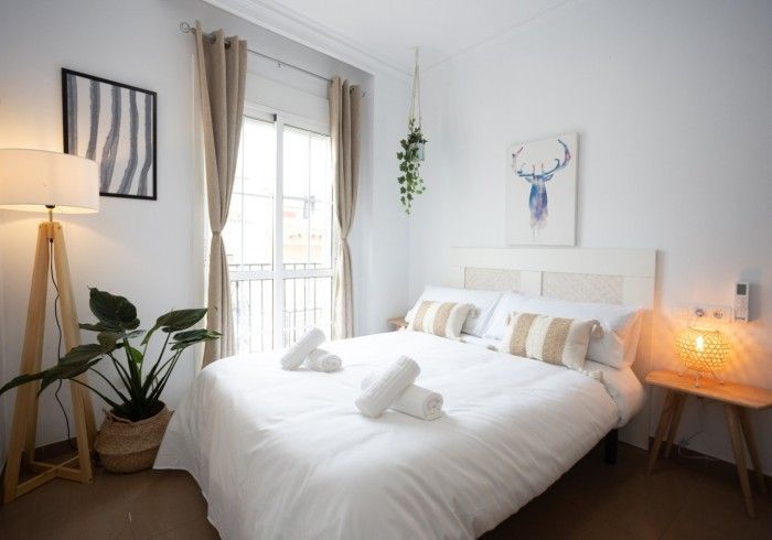 Un dormitorio con una cama grande y una lámpara.