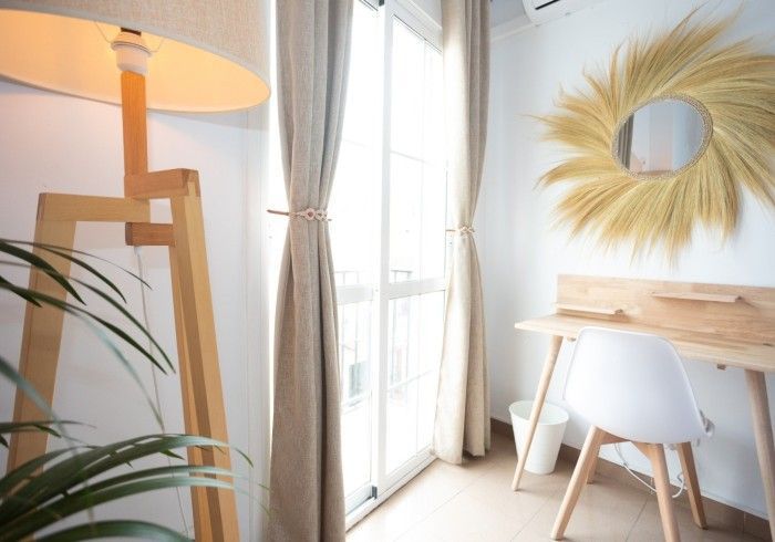 Una habitación con una lámpara y un espejo en la pared.