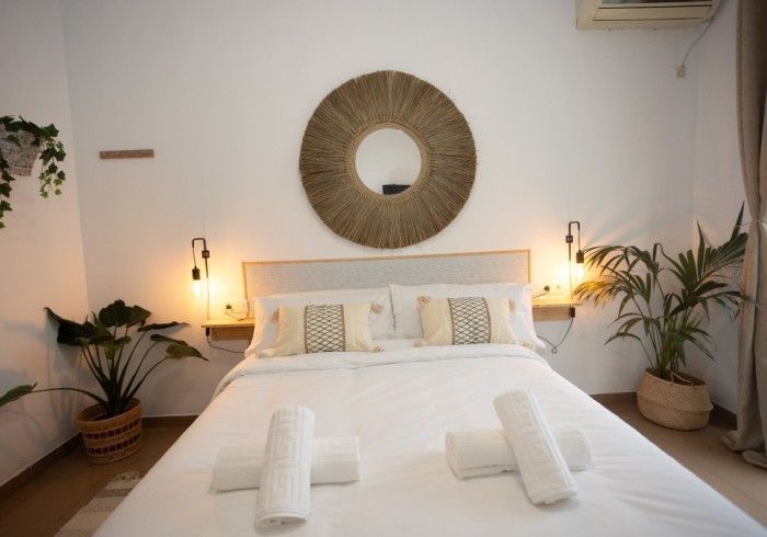 Un dormitorio con una cama y un espejo en la pared.