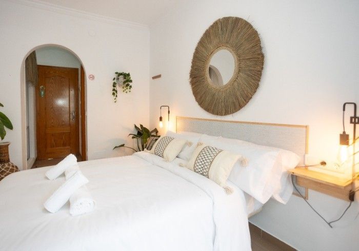 Un dormitorio con una cama y un espejo en la pared.