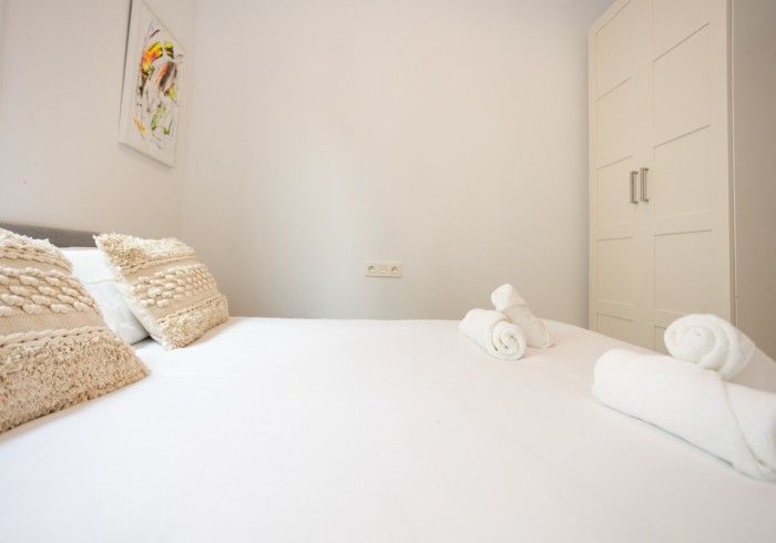 Un dormitorio con una cama, almohadas y toallas.