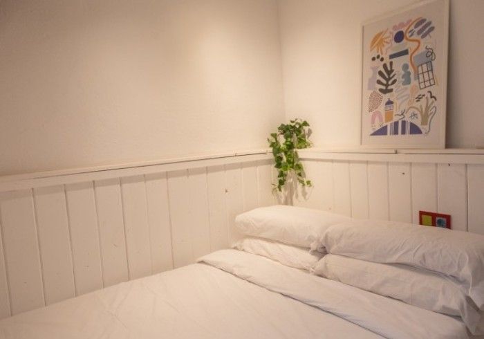 Un dormitorio con una cama y un cuadro en la pared.