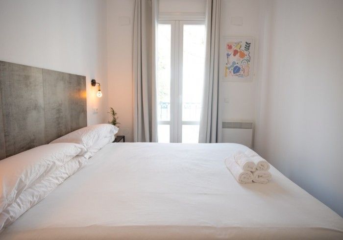Un dormitorio con una cama king size y una ventana.