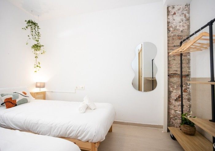 Un dormitorio con dos camas y un espejo en la pared.