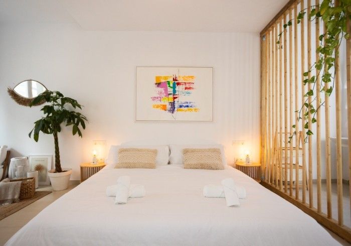 Un dormitorio con un cuadro en la pared encima de la cama.