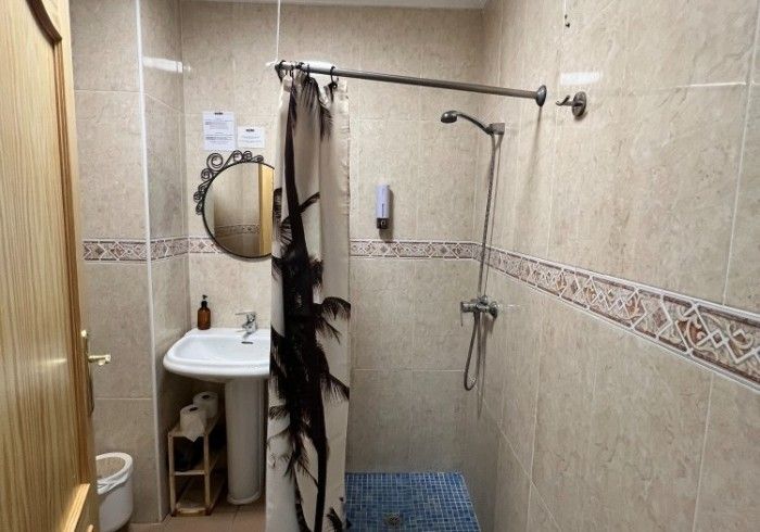 Un baño con lavabo, inodoro, ducha y espejo.