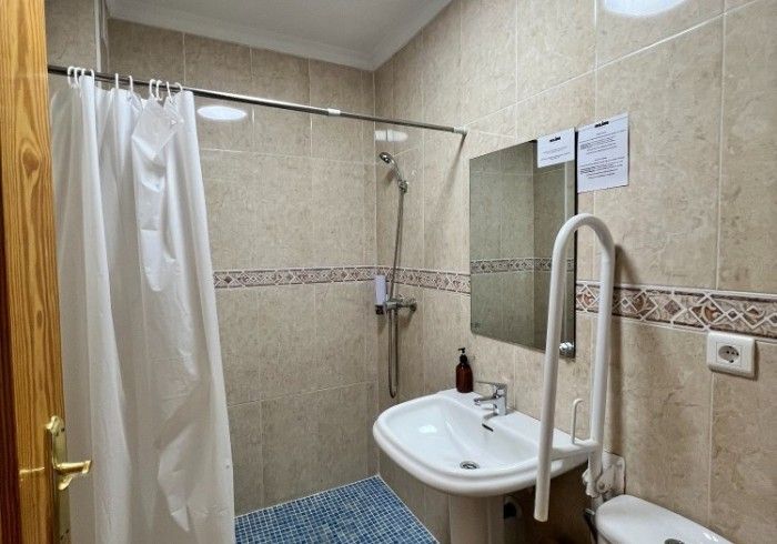 Un baño con lavabo, inodoro, ducha y espejo.
