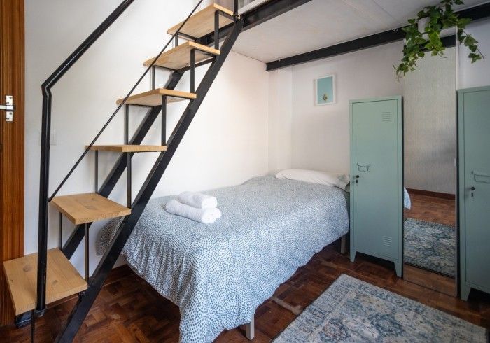 Un dormitorio con una cama y escaleras que conducen a él.