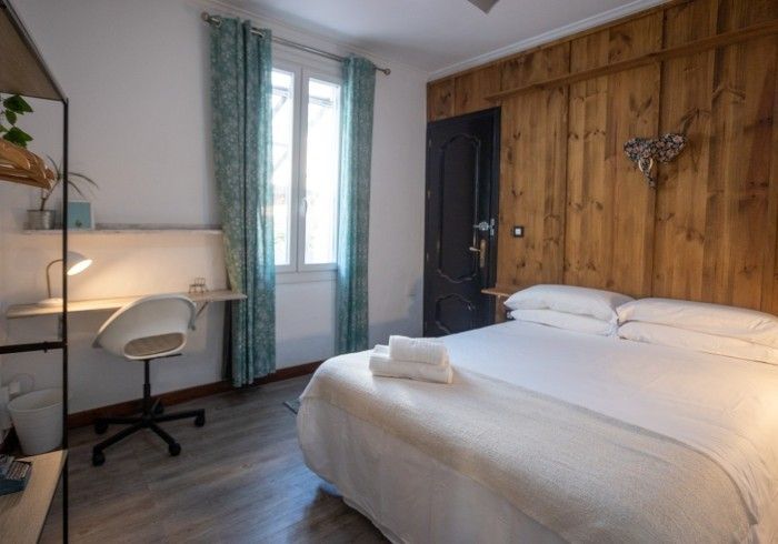 Un dormitorio con una cama, un escritorio y una silla.