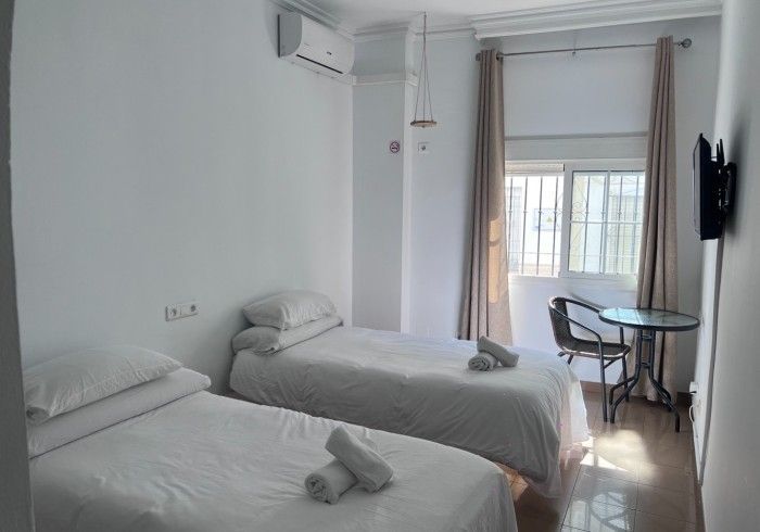 Un dormitorio con dos camas, una mesa y una televisión.