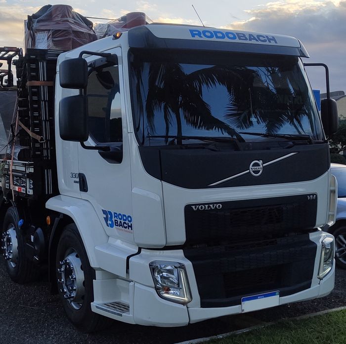Um caminhão Volvo branco está estacionado na beira da estrada