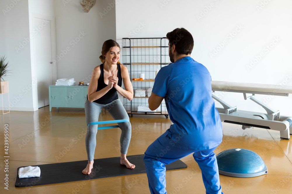 Therapist working with a patient using leg bands.