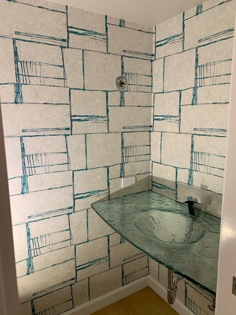 A bathroom with a brick wall and a glass sink