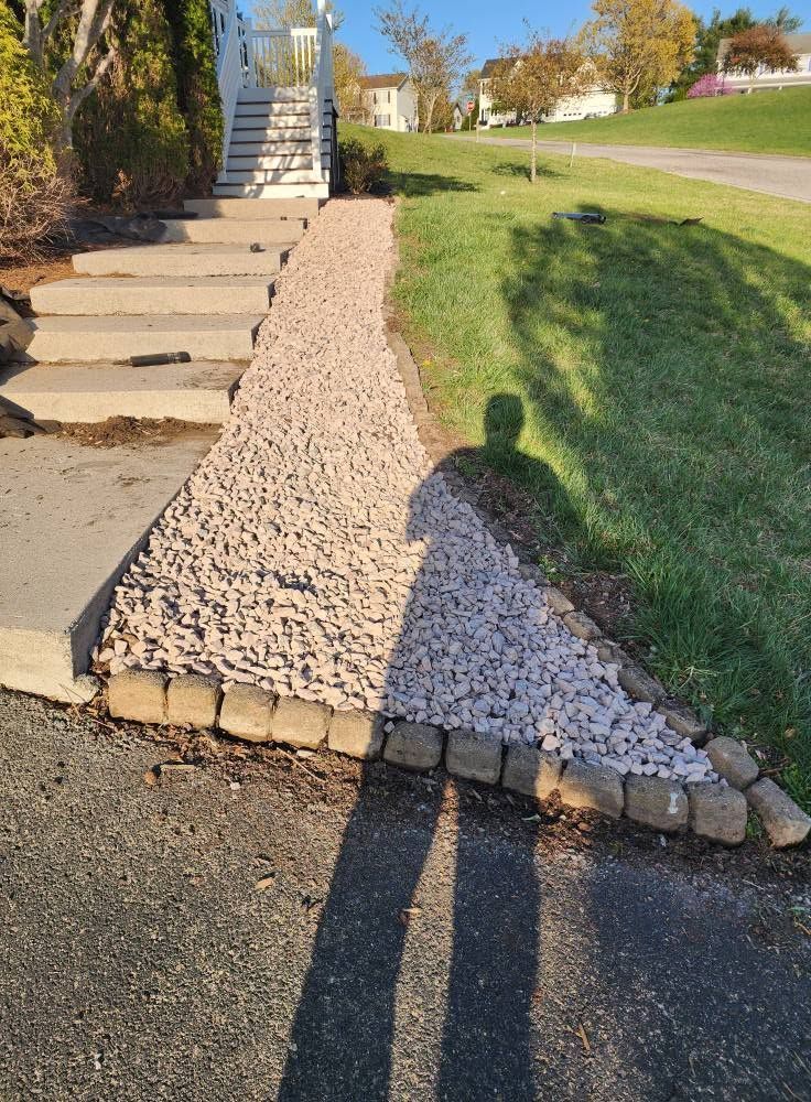 Rock path beside steps and grassy slope in a sunny outdoor park setting